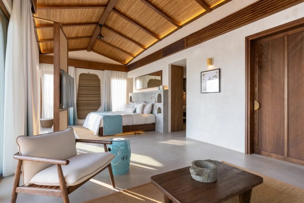a mid century modern armchair in a japandi tropical style hotel suite