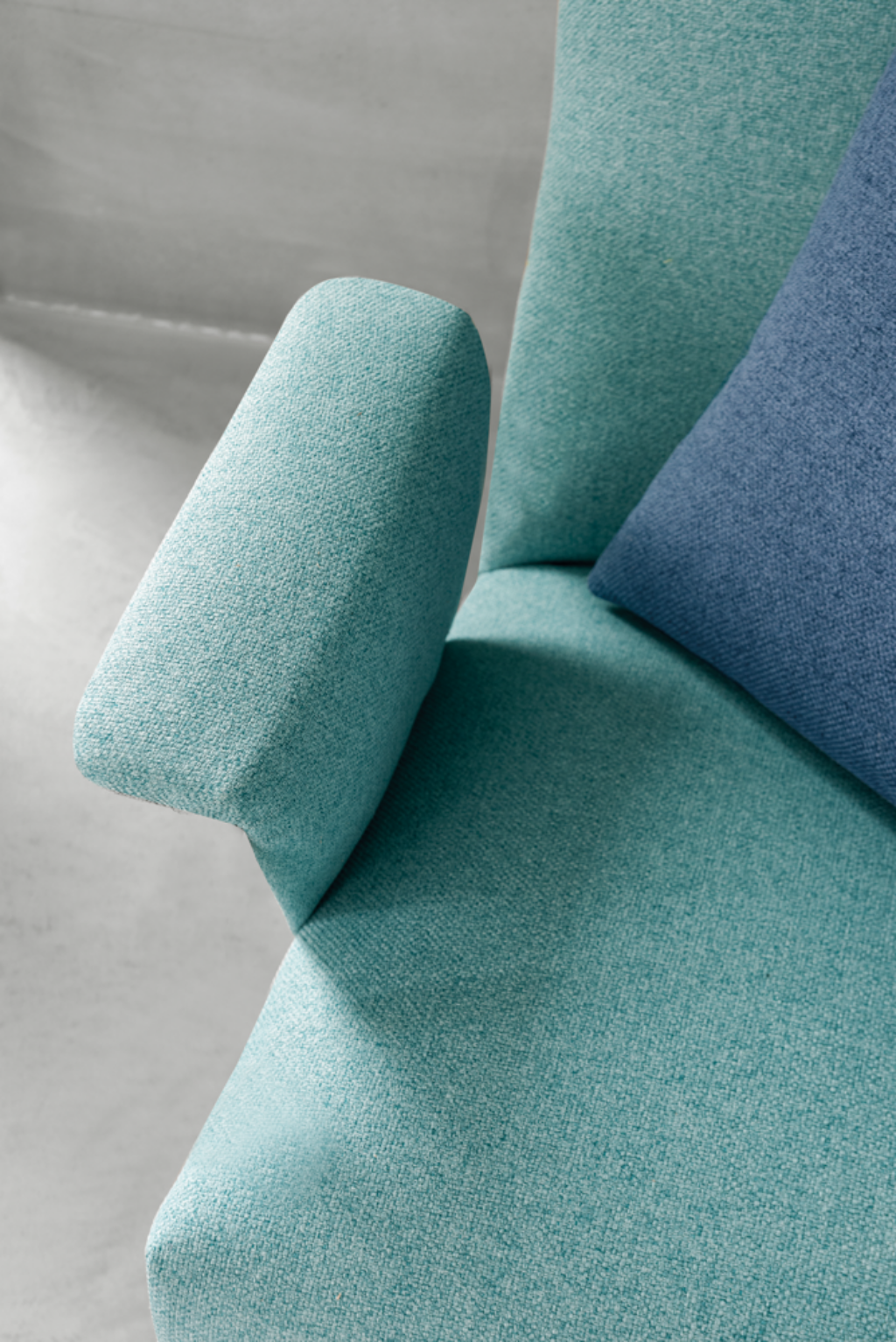 a detailed shot of a seafoam green armchair in a hospital waiting room
