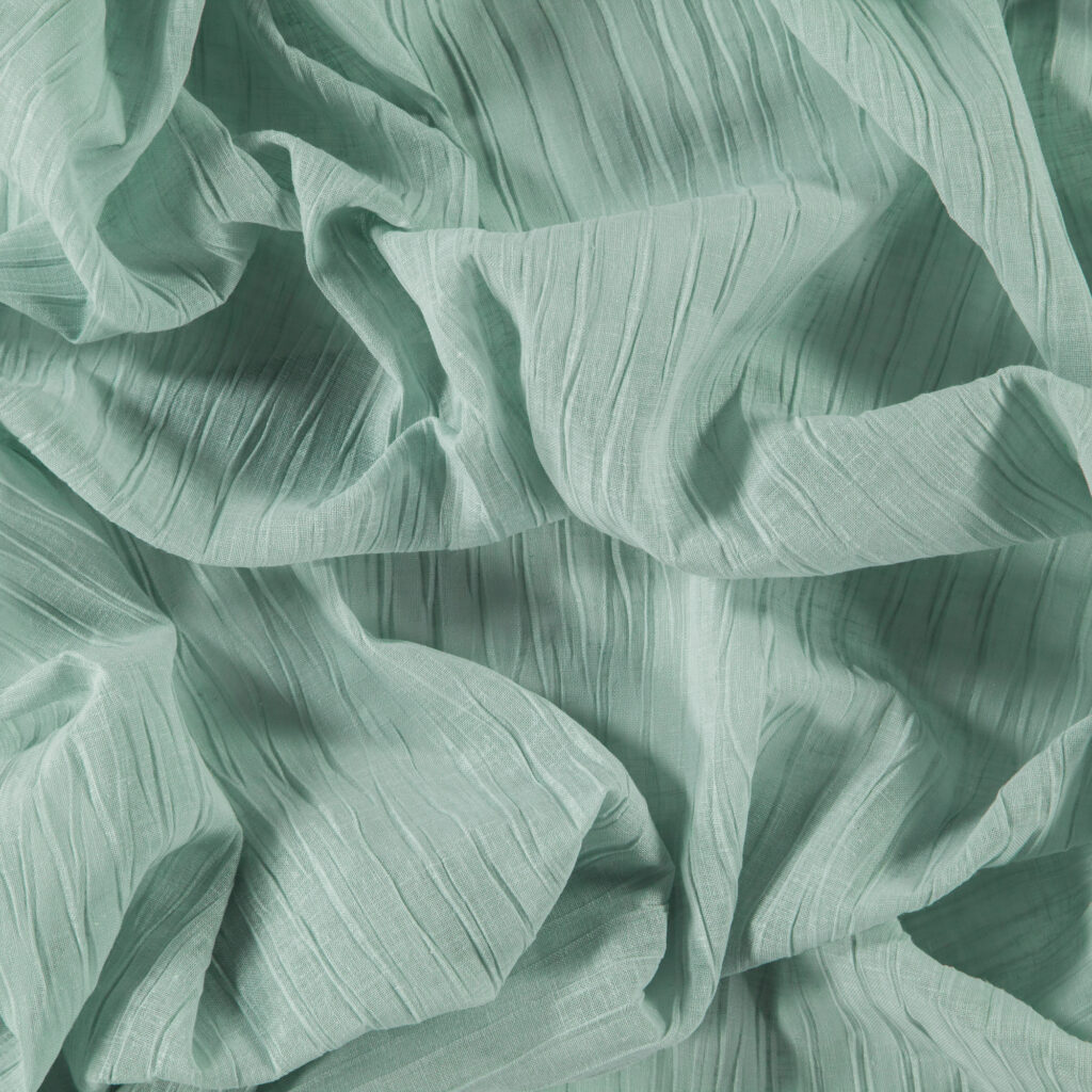 An overhead shot of FibreGuard aqua-coloured fabric scrunched up to show its lustre and texture