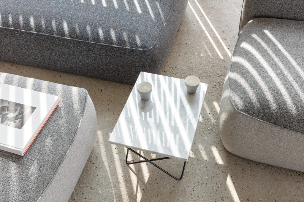sunlight streams through the window in bars, putting the stylish furniture in the room all in stripes