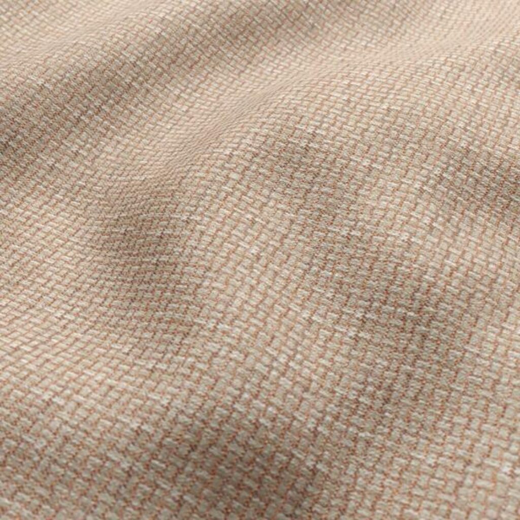 Close-up view of a neutral-coloured plain jacquard upholstery fabric, highlighting the design and texture of the upholstery material