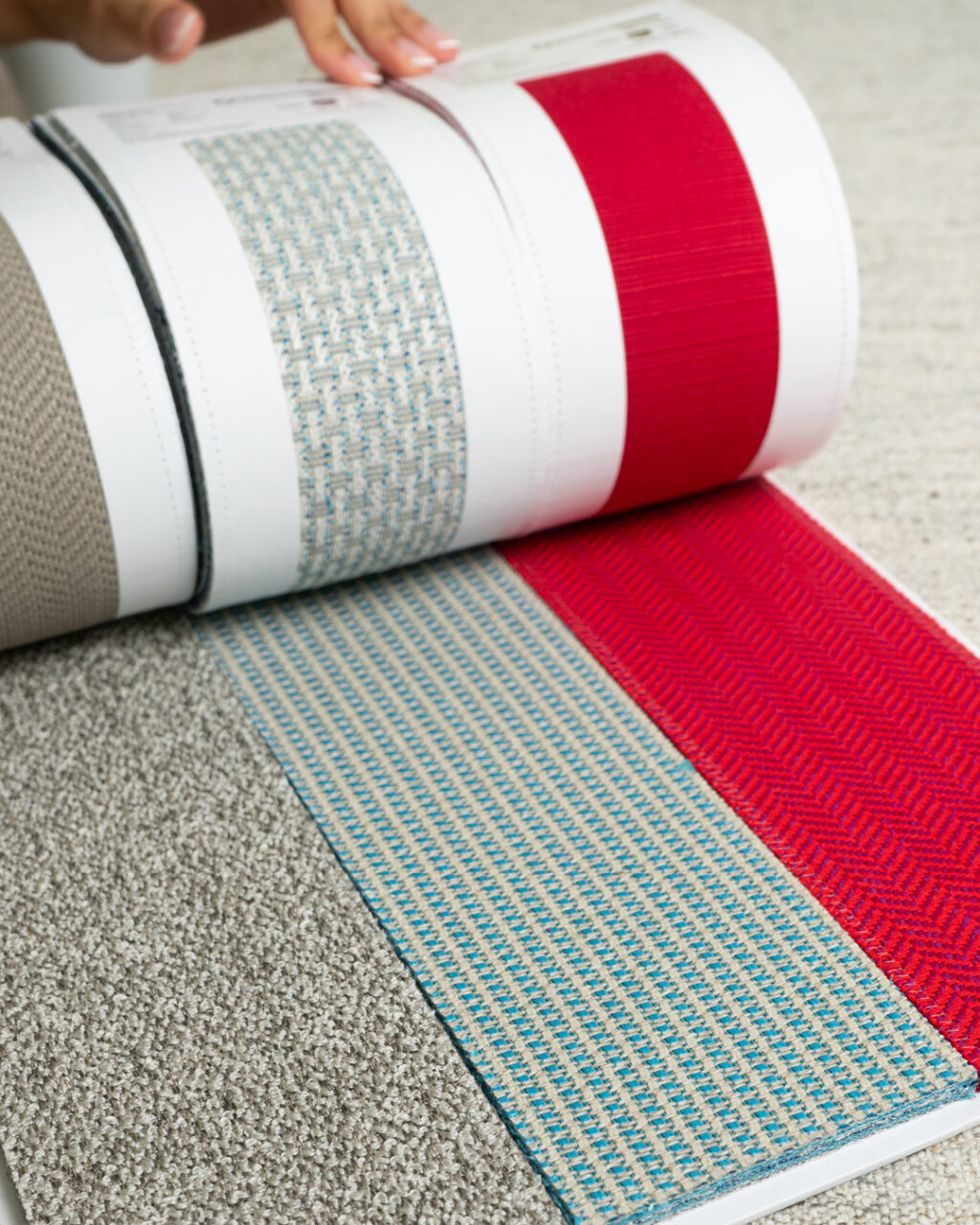Three fabric swatches, one in beige, one in aqua and one in red