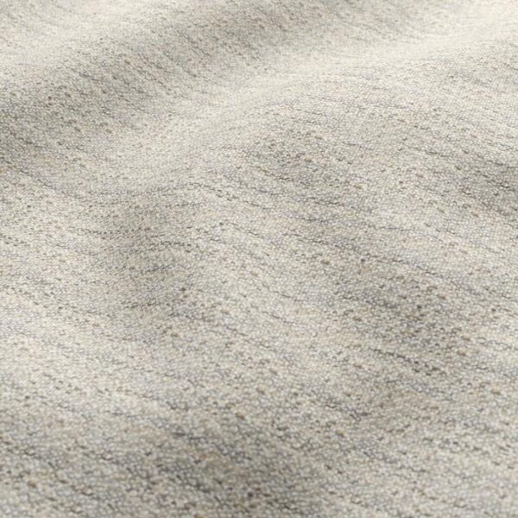 Close-up view of a light coloured textured plain upholstery fabric, highlighting the design and texture of the upholstery material