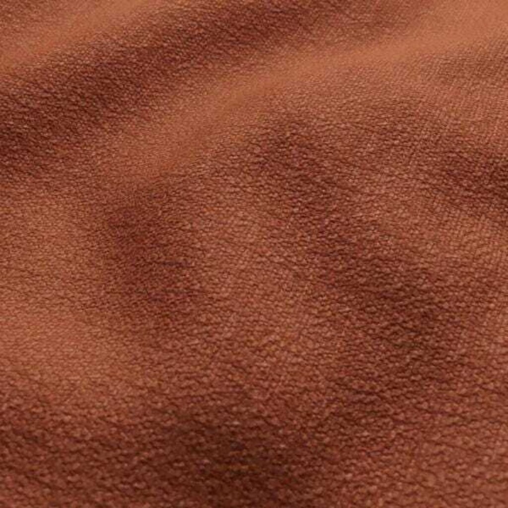 A close-up image of brown fabric, emphasising its softness and deep color