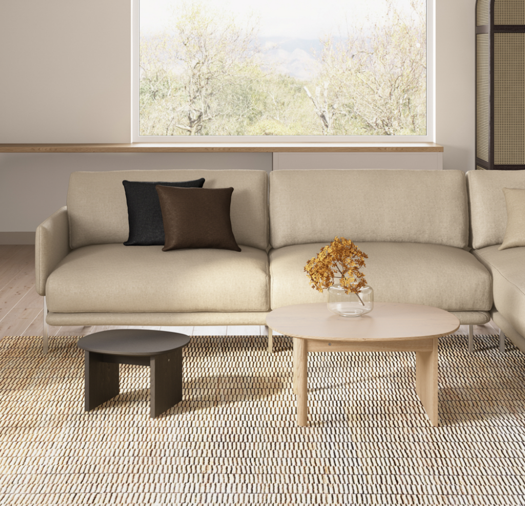 front view of a comfortable looking living room with a neutral-coloured sofa, brown cushions, and a textured rug